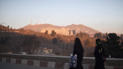 Two Afghan women walk past the Intercontinental Hotel after an attack in Kabul. Shah Marai / AFP Photo
