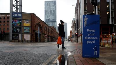 A woman walks near a social distancing sign in Manchester. Reuters