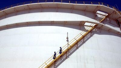 Oil technicians climb down a giant tank at a refinery in Jebel Ali. Kamran Jebreili / AP Photo