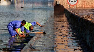 Municipality workers try to drain a flooded underpass in Kuwait City. AFP