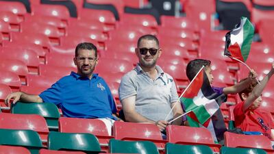 Supporters hold Palestinian flags as they sit in the stands prior to the match. AP Photo