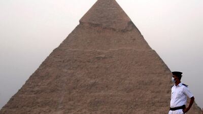 An Egyptian policeman wearing a protective face mask takes his position, in front of the Pyramid of Khufu or Pyramid of Cheops during the opening of a new restaurant called 9 Pyramids Lounge. Reuters