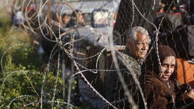 Palestinians hoping to cross into Egypt wait behind a barbed wire fence at the Rafah crossing between Egypt and the southern Gaza Strip.
