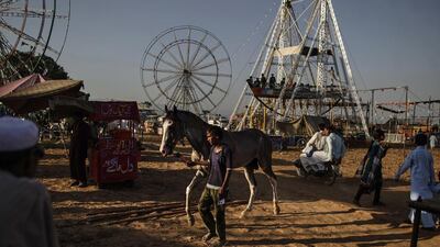 A Pakistani boy walks his horse at an entertainment park in Rawalpindi, Pakistan.
