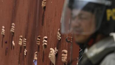 Police block a gate at the appeal court in central Phnom Penh, where about 200 people gathered in protest on February 11, 2014. The Cambodian court on Tuesday denied bail to 21 rights defenders and garment workers jailed in January, after a deadly crackdown on striking workers over higher wages. The clash left five people dead and many more wounded, local rights groups said. Samrang Pring / Reuters