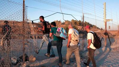 Palestinian workers cross illegaly into Israeli areas through a hole in Israel's barrier fence near the Mitar checkpoint and the village of al-Dahriya, south of Hebron in the occupied West Bank. AFP