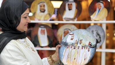 Aziza Al Kandri holds up one of her hand painted plates on sale in Dubai until Saturday. Chris Whiteoak / The National
