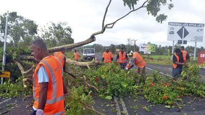 Road workers remove a fallen tree blocking a road near Lami, Fiji on February 21, 2016, after cyclone Winston ripped through the country. Officials in Fiji are assessing damage in the wake of the ferocious cyclone. Jonacani Lalakobau/Fiji Times via AP
