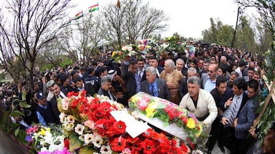 Iraqi Kurds lay flowers at the foot of a monument built in memory of the Iraqi Kurd victims who were killed in a gas attack.