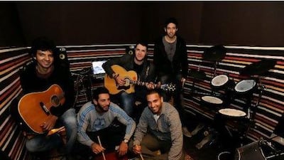 Members of the Cairo-based band Cairokee from left, in chairs, Sherif Hawary, Amir Eid, Sherif Mustafa, and from left on the floor, Tamer Hashem and Adam El Alfy in their studio at Eid's home in Maadi. Photos by Dana Smillie for The National