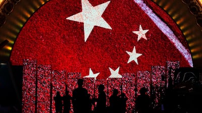 Visitors watch video display boards showing the Chinese flag at an exhibition highlighting the country's achievements under five years of leadership by President Xi Jinping. Andy Wong / AP Photo