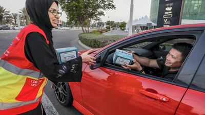 Red Crescent volunteers and Abu Dhabi Police distribute food to motorists during iftar at the corner of 11th Street and 18th. Victor Besa / The National