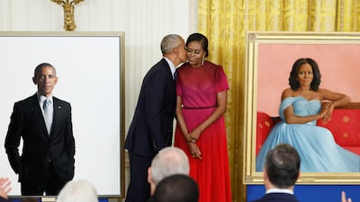 Former US president Barack Obama kisses former first lady Michelle Obama during the unveiling of their official White House portraits, painted by Robert McCurdy and Sharon Sprung, respectively. Reuters