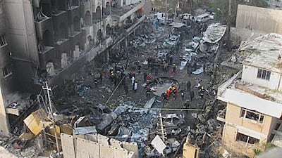 Security forces examine the site of one of 14 bomb blasts in Baghdad yesterday that killed more than 60 people and injured nearly 200.