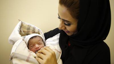 Mahra Al Yaqoobi holds her niece Noura Al Nadhari, who arrived at 5.52am on Eid Al Adha on Monday at the Corniche Hospital in Abu Dhabi. Ravindranath K / The National
