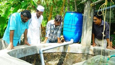 Volunteers from Miles, a village empowerment initiative started by a Dubai-based doctor, check a rain water harvesting project that aims to help villagers of Kalpakanchery in southern India's Kerala state who suffer from water scarcity.
