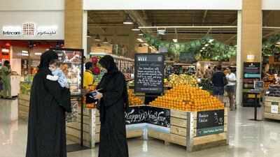 People shop at Spinneys in Dubai. The supermarket chain is considering introducing a charge for plastic bag use. Reem Mohammed / The National