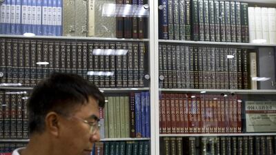 A man walks by Chinese encyclopaedias at a book store in Beijing. China is starting to compile a free online encyclopaedia to rival Wikipedia. Andy Wong / AP Photo