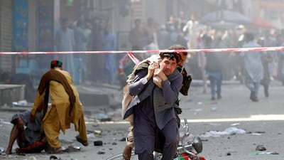 A man caries a wounded person to the hospital after one of several bombings in Jalalabad on August 19, 2019. Reuters