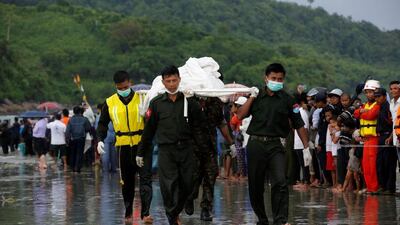 Military soldiers carry dead bodies from a crashed military plane outside Launglon township, Myanmar June 8 , 2017. Soe Zeya Tun / Reuters