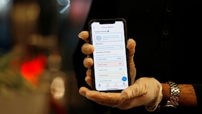 A man wearing protective gloves shows the interface of the app "Be Aware", launched by Bahrain's health authorities to contain the coronavirus disease, at a hotel in Manama, Bahrain. Reuters