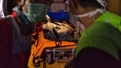 Search and rescue workers move the remains of a victim. Getty Images