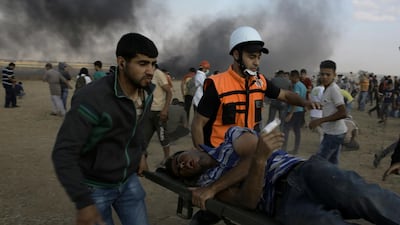 Palestinian medics and protesters evacuate a wounded youth near the Gaza Strip's border with Israel, during a protest east of Khan Younis, in the Gaza Strip, Friday, June 1, 2018.