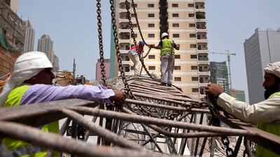 Construction workers work away to clean up remains of a crane that collapsed earlier that morning on Tuesday, July 12, 2011, during the morning rush hour in downtown Abu Dhabi. No one was hurt and only road blocks and the crane itself suffered damages. (Silvia Razgova/The National)