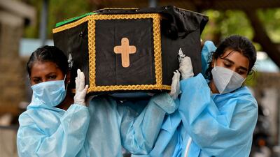 Volunteers Akshaya, 22, right, a law student, and Esther Mary, 41, a lecturer, carry the body of a Covid-19 victim for burial at a cemetery in Bengaluru, India. Reuters