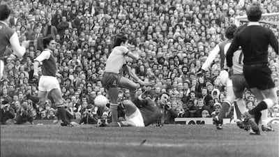Arsenal are beaten 4-1 at home by Ipswich. Gunners Goalkeeper Jimmy Rimmer rushes out to make a sliding tackle on visiting defender Brian Talbot, March 5, 1977 . Shutterstock