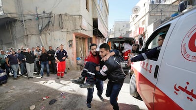 An injured Palestinian man is evacuated by members of the Red Crescent on February 15, 2016 at the Amari Palestinian refugee camp, near the West Bank city of Ramallah, during clashes with Israeli soldiers. Abbas Momani/AFP