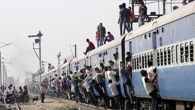 Indian passengers hang and sit on an overcrowded train as it departs from Loni town, in Uttar Pradesh on February 26. EPA