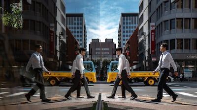 Pedestrians reflected in glass as they walk in the Ginza district of Tokyo. AFP