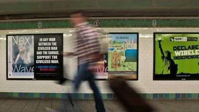 A commuter walks past an anti-Muslim poster in New York's Times Square subway station. A federal judge ruled that the advertisement is protected speech under the First Amendment of the US Constitution.