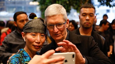 Tim Cook, chief executive of Apple., takes a selfie with a customer and her iPhone as he visits the Apple Store in Chicago, Illinois. John Gress / Reuters