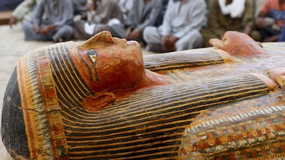Excavators sit behind painted ancient coffins at Al-Asasif necropolis, unveiled by Egyptian antiquities officials in the Valley of the Kings in Luxor, Egypt. REUTERS