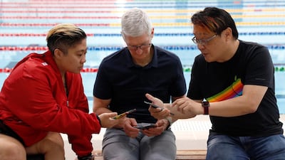 Apple's chief executive Tim Cook (in the middle) sharing a selfie photo via Airdrop with others at the Singapore Sports Hub last month. Reuters