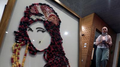 Egyptian artist Amal Salah, 35, stands by her artwork "You Know I'm No Good", made of medicine pills, depicting late singer Amy Winehouse, as part of a mental health project in Cairo, Egypt. Reuters