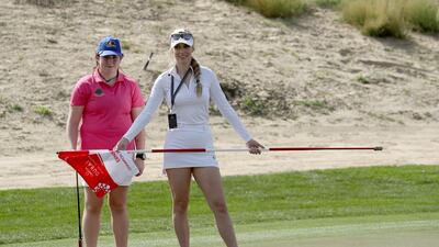 Saoirse Lambe of Ireland, who won a global competition to play with Rory McIlroy and Niall Horan is assited by Paige Spiranac during the pro-am at Emirates Golf Club. David Cannon / Getty Images