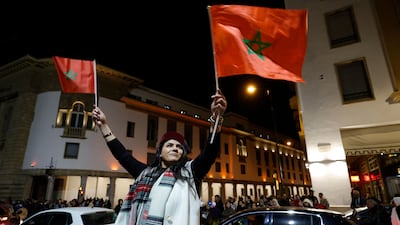 A woman waves the Moroccan flag as football fans in Rabat celebrate the national team's Arab Cup victory. AFP