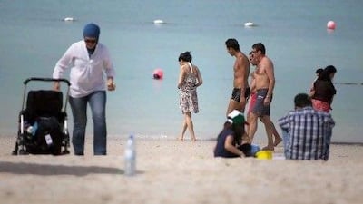 People enjoy the public beach on Abu Dhabi's Corniche. Many women say they still feel uncomfortable on mixed beaches and are calling for the reinstatement of segregated areas.
