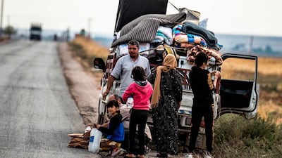 Syrian Kurdish and Arab families are pictured fleeing in the countryside of the town of Darbasiyah, on the border between Syria and Turkey, towards the town of Hassakeh. AFP