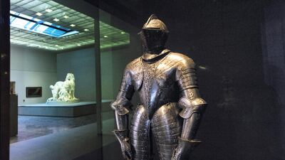 An ornate suit of French armour from the 16th century with a view through to Gilles Guérin’s Horses of the Sun sculpture (1665-1672). Christopher Pike / The National