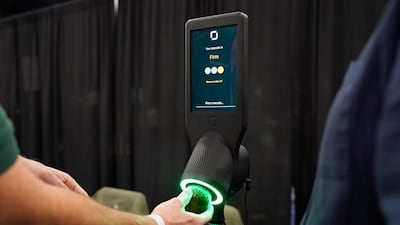 An exhibitor demonstrates the OneThird avocado ripeness checker, a device that allows shoppers to scan an avocado in a store and find out when it is ready to eat. AP