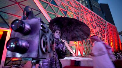 An actor poses with a replica cinema projector as visitors arrive at an invitation-only screening of Black Panther. Amr Nabil / AP Photo