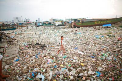 A child walks through piles of garbage in Tondo, the most densely populated district in Manila, Philippines. Jake Versoza for The National