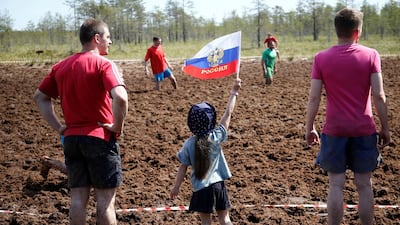 A girl holds a flag as she attends the Swamp Football Cup of Russia in the village of Pogi in Leningrad Region, Russia June 16, 2018. Anton Vaganov / Reuters