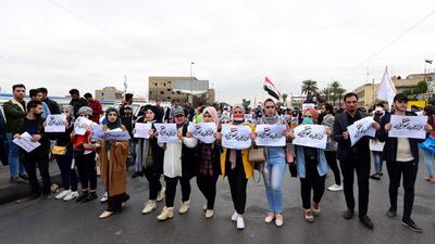Iraqi university students carry placards reading in Arabic 'My loyalty to Iraq', during a strike and protests in central Baghdad, Iraq. EPA