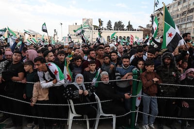 Syrians wave flags during celebrations marking one year since the regime change. AFP