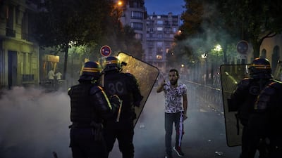A Paris Saint-Germain fan taunts French riot police outside the Parc de Princes stadium. Getty